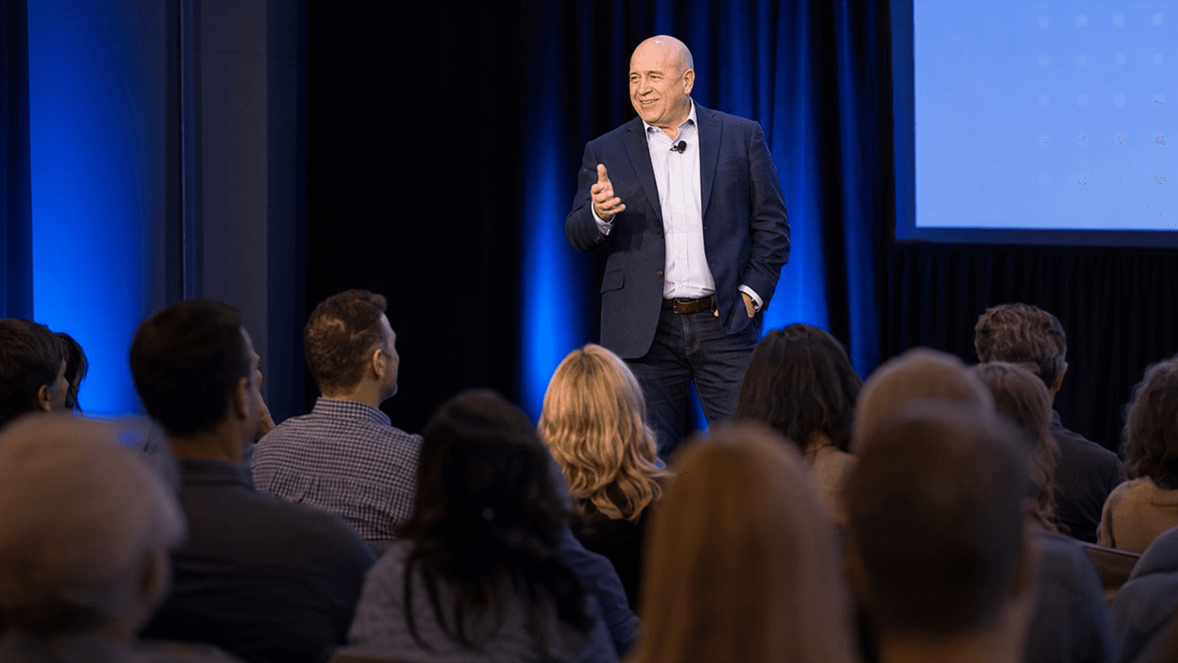 Paul speaking to an audience from a stage